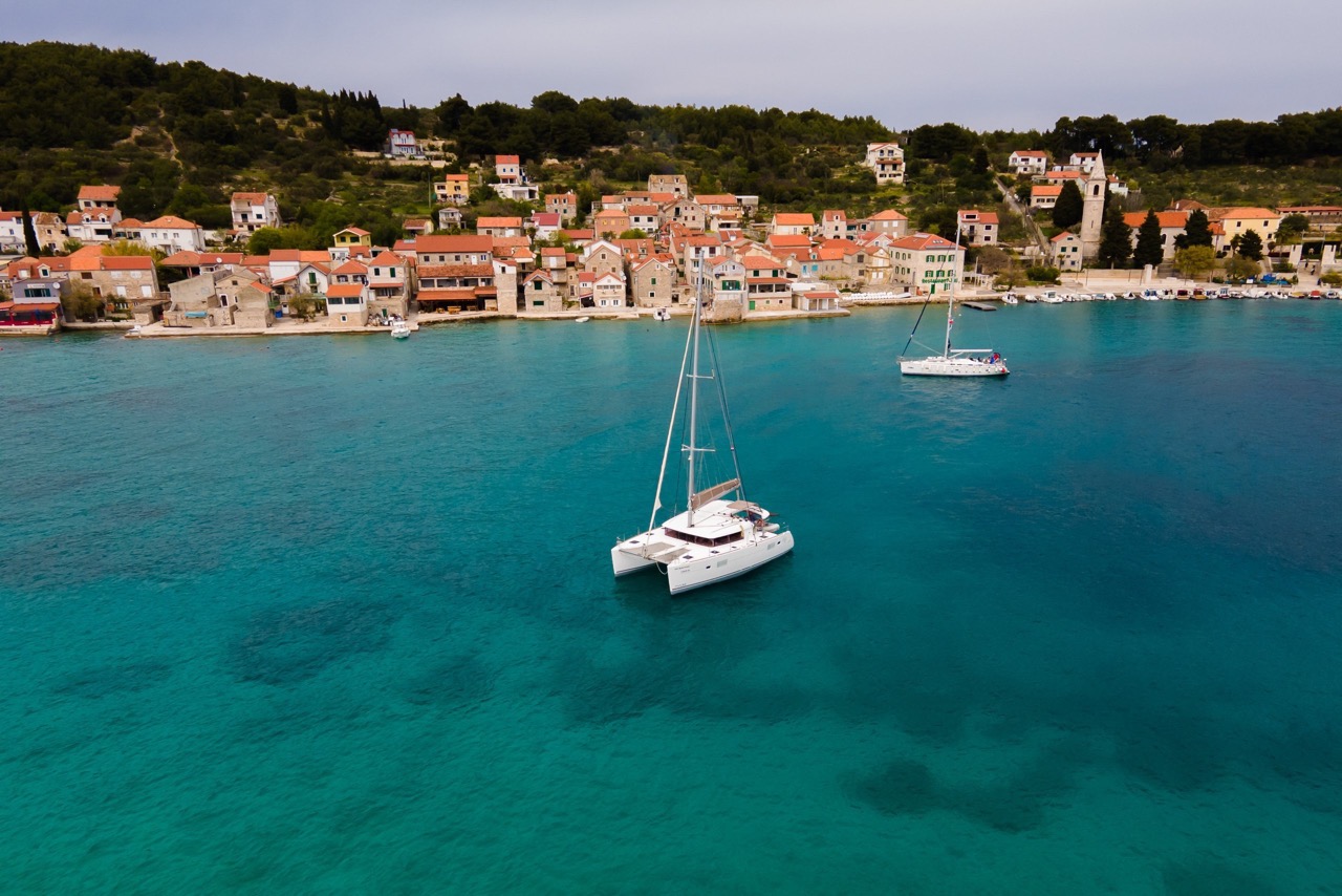 Miss Moneypenny vor Anker im türkisen Wasser vor einem dalmatinischen Dorf